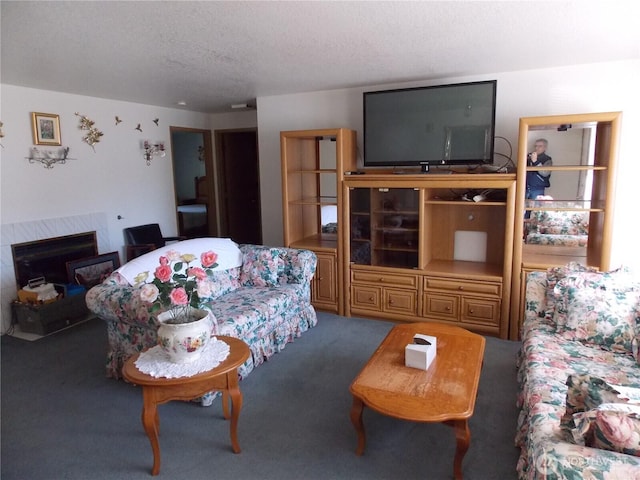 living area featuring carpet, a textured ceiling, and a tile fireplace