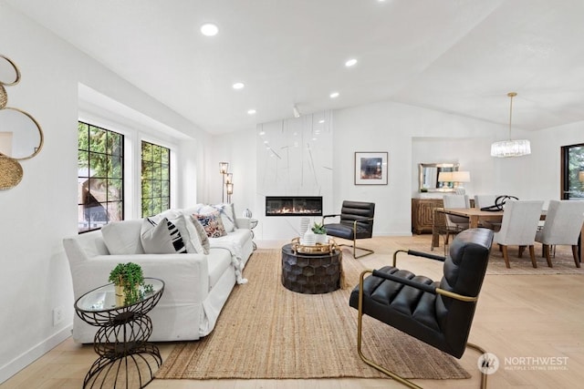 living room featuring vaulted ceiling, a chandelier, light parquet flooring, and a high end fireplace