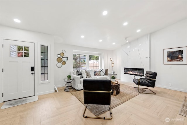 living room featuring light parquet flooring and a large fireplace