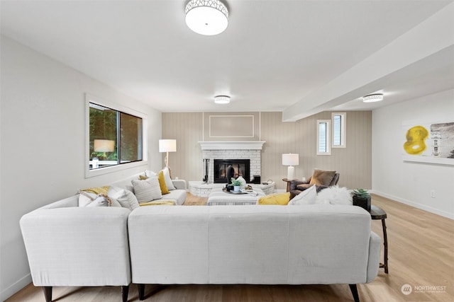 living room featuring a brick fireplace and hardwood / wood-style flooring