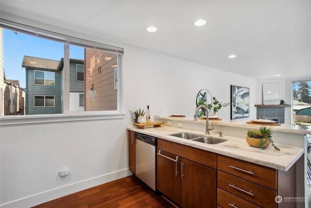 kitchen with sink, dishwasher, light stone counters, dark hardwood / wood-style flooring, and kitchen peninsula