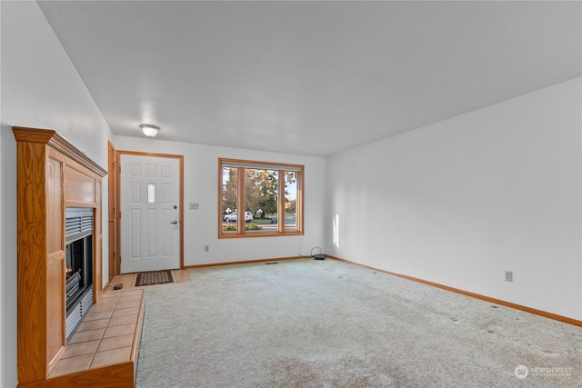 unfurnished living room featuring light carpet and a fireplace