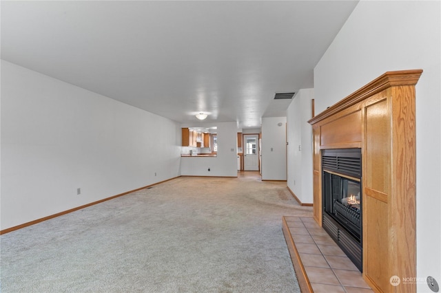 unfurnished living room with light colored carpet and a fireplace