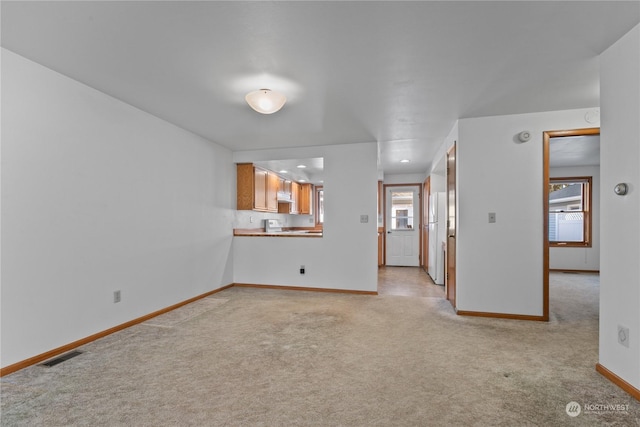 unfurnished living room with plenty of natural light and light carpet