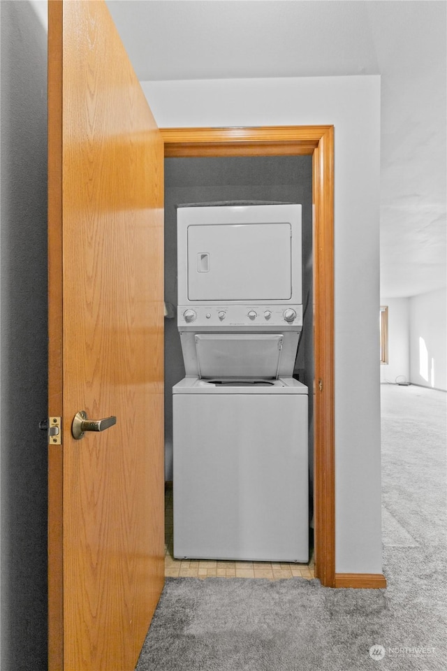 clothes washing area with stacked washer / dryer and light colored carpet