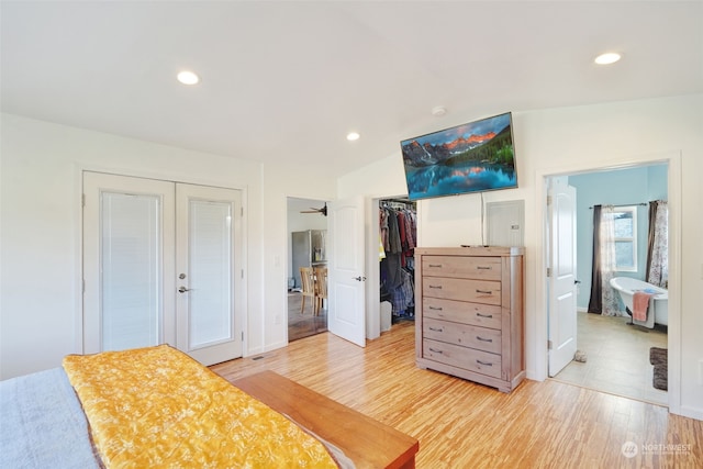 bedroom featuring recessed lighting, a walk in closet, lofted ceiling, and light wood-style floors