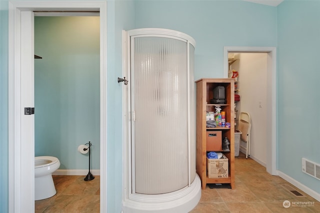 bathroom featuring visible vents, a shower stall, toilet, and baseboards