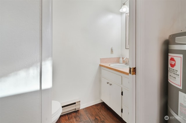 bathroom with baseboards, toilet, wood finished floors, vanity, and a baseboard radiator