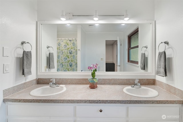 bathroom featuring double vanity, curtained shower, crown molding, and a sink