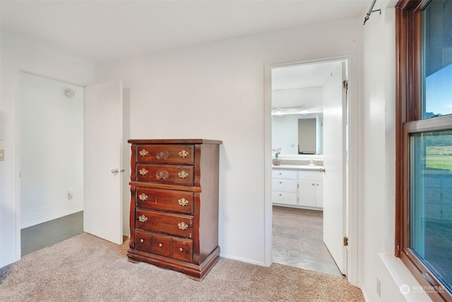 unfurnished bedroom featuring a sink, carpet, and ensuite bathroom