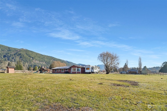 view of yard featuring a rural view, a mountain view, and a playground