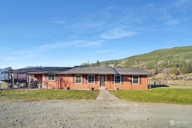 single story home featuring a front lawn, fence, and a mountain view