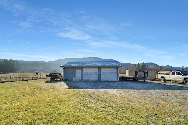 detached garage featuring a mountain view and fence