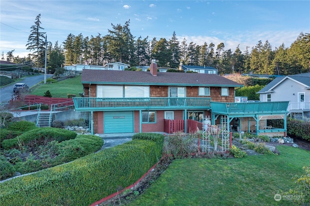 view of property with a garage, a front lawn, and a deck