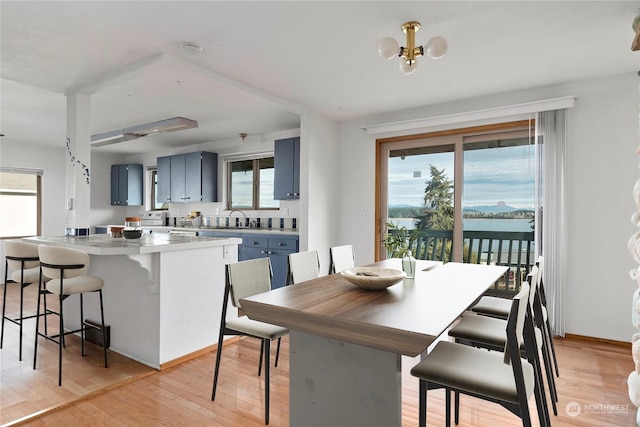 550 SW Waterloo Ave, Oak Harbor, WA 98277 - dining room featuring an inviting chandelier, sink, light hardwood / wood-style floors, and a water view