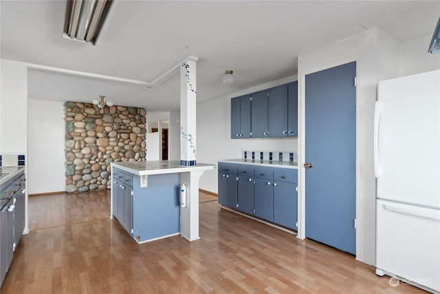 550 SW Waterloo Ave, Oak Harbor, WA 98277 - kitchen with blue cabinets, light wood-type flooring, a breakfast bar area, and white refrigerator