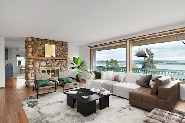 550 SW Waterloo Ave, Oak Harbor, WA 98277 - living room featuring a stone fireplace, hardwood / wood-style flooring, and a water view