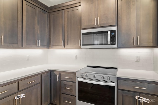 kitchen featuring appliances with stainless steel finishes, dark brown cabinets, and backsplash