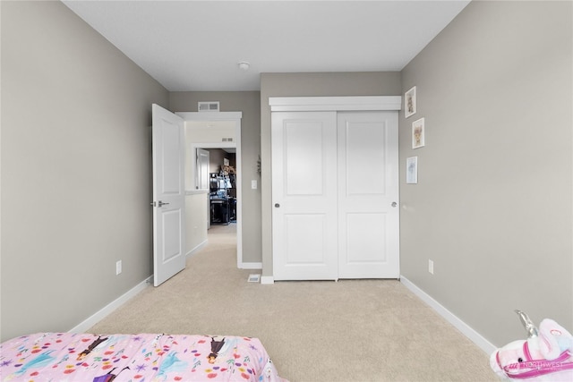 bedroom with light carpet and a closet