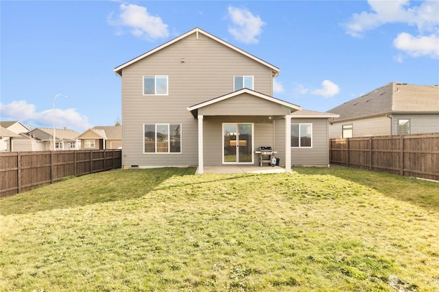 rear view of house with a patio and a lawn