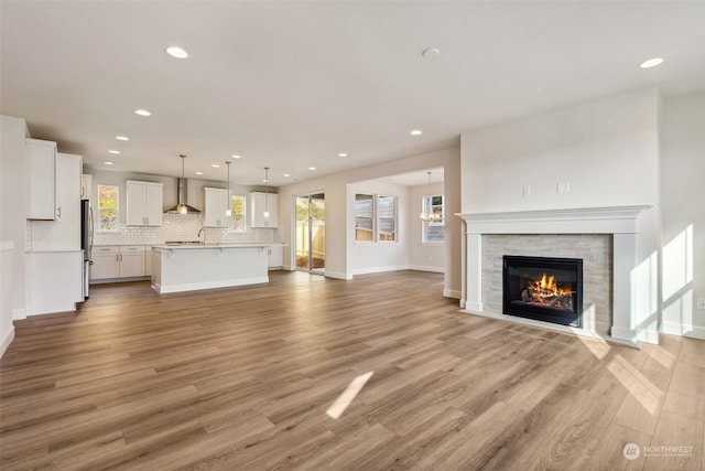 unfurnished living room featuring plenty of natural light and light hardwood / wood-style flooring