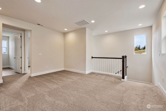 unfurnished room featuring light colored carpet