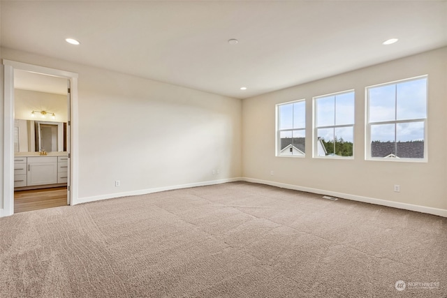 unfurnished room featuring light colored carpet