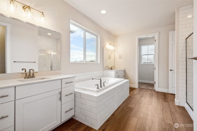 bathroom featuring independent shower and bath, vanity, and hardwood / wood-style floors