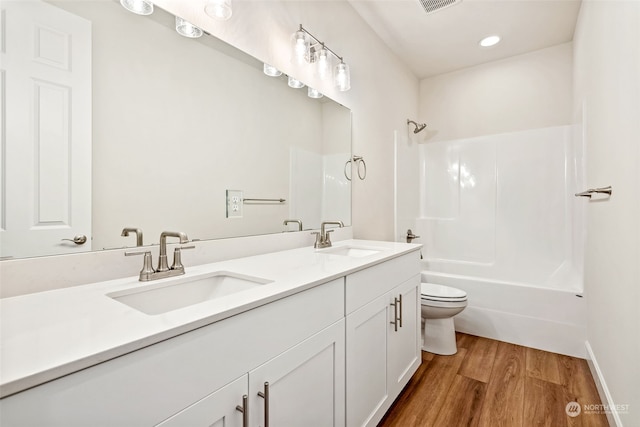 full bathroom with vanity, hardwood / wood-style flooring, toilet, and washtub / shower combination