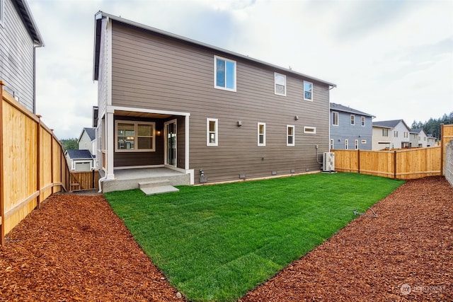 rear view of property featuring central AC unit and a lawn