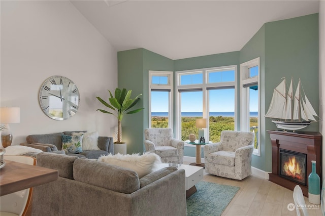 living room featuring a water view, lofted ceiling, and light wood-type flooring