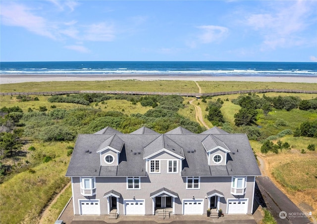 drone / aerial view featuring a beach view and a water view