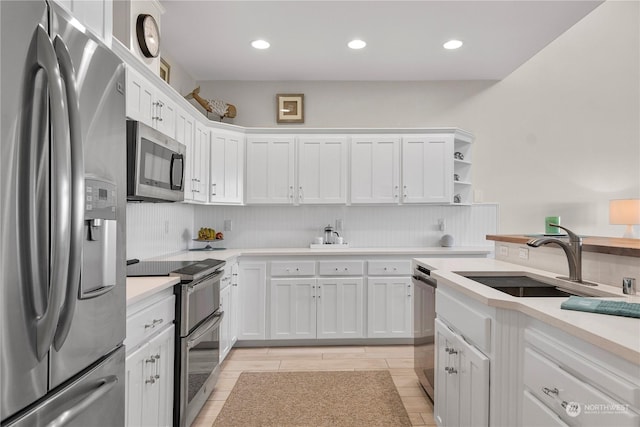 kitchen featuring white cabinetry, appliances with stainless steel finishes, sink, and backsplash