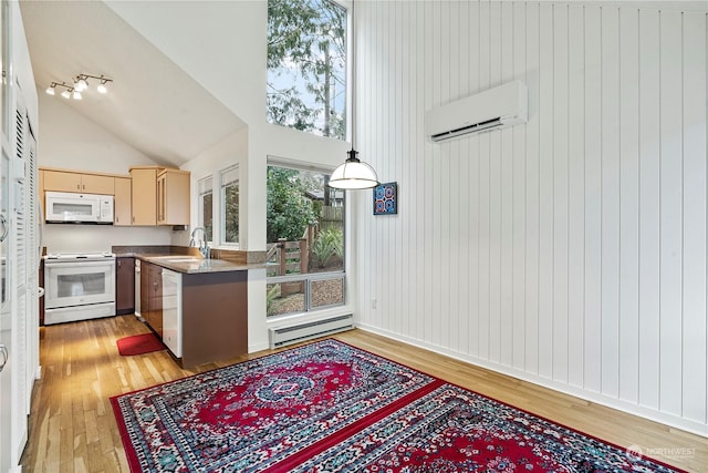 kitchen with white appliances, baseboard heating, light wood-type flooring, a sink, and a wall mounted AC