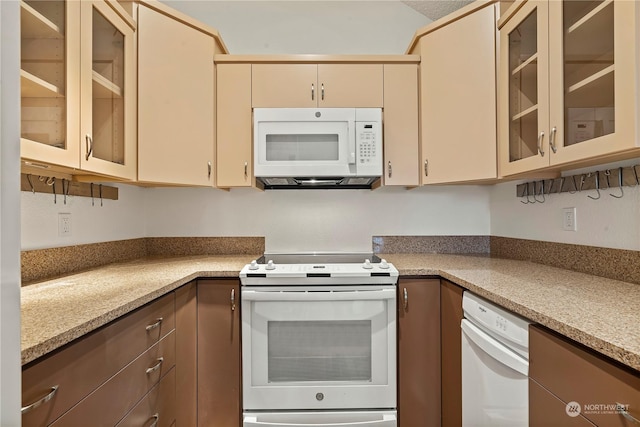 kitchen with white appliances, glass insert cabinets, and cream cabinetry