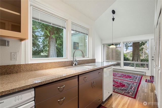 kitchen with lofted ceiling, white dishwasher, a healthy amount of sunlight, a baseboard heating unit, and a sink