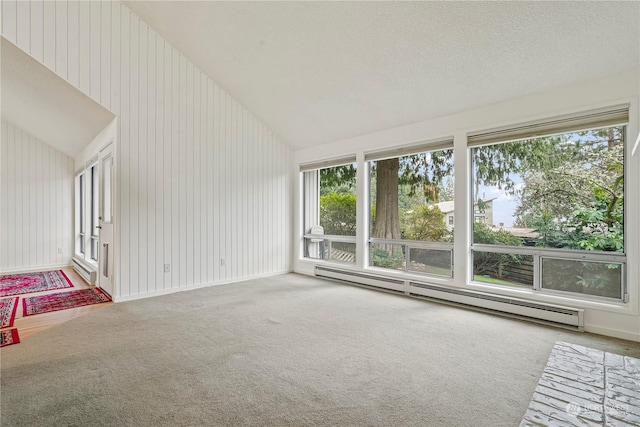 unfurnished living room featuring carpet floors, a baseboard heating unit, vaulted ceiling, and a textured ceiling