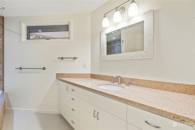 bathroom featuring a shower, vanity, and baseboards