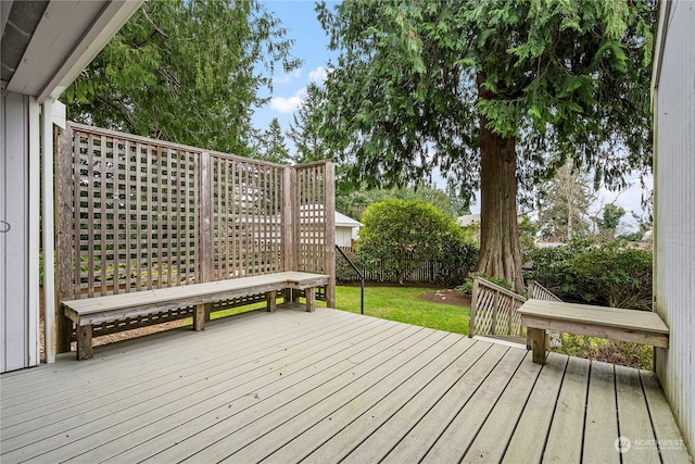 wooden deck with a lawn and fence