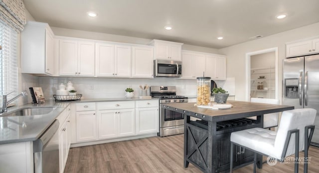 kitchen featuring white cabinetry, appliances with stainless steel finishes, sink, and a center island