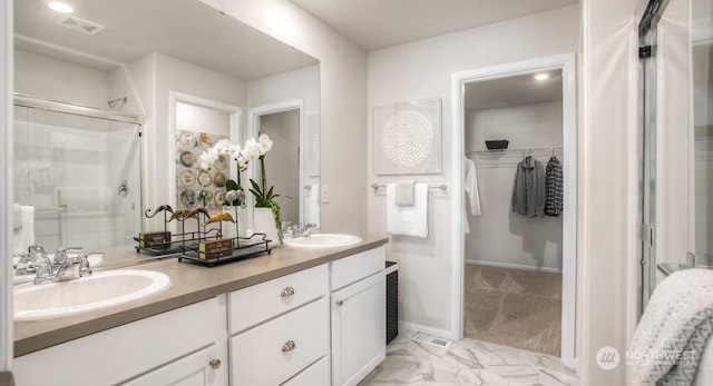 bathroom featuring vanity and a shower with door