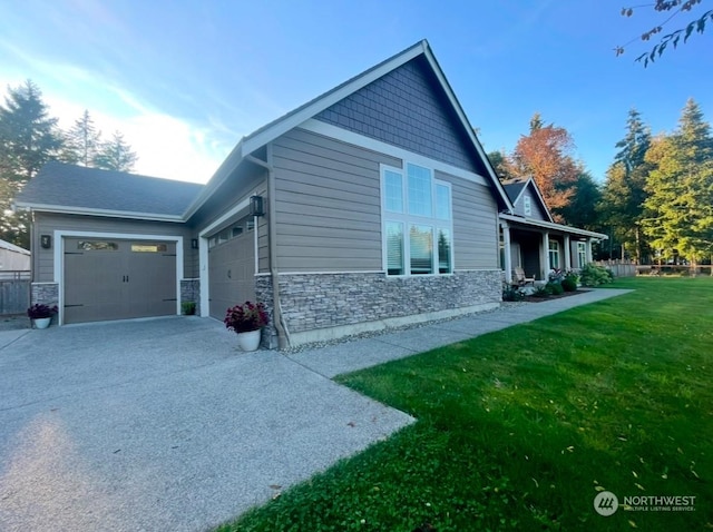 view of home's exterior featuring a yard, a garage, and a porch