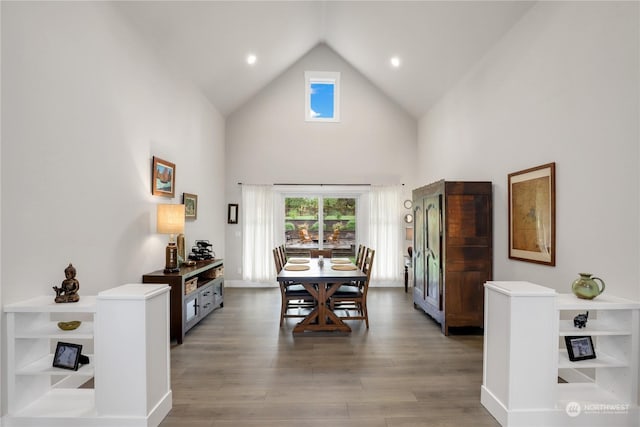 dining space with hardwood / wood-style floors and high vaulted ceiling