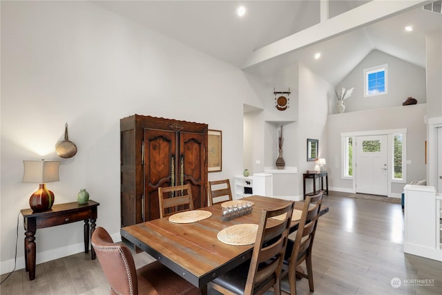 dining area featuring dark hardwood / wood-style floors and high vaulted ceiling