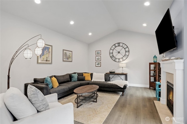 living room featuring lofted ceiling and light wood-type flooring