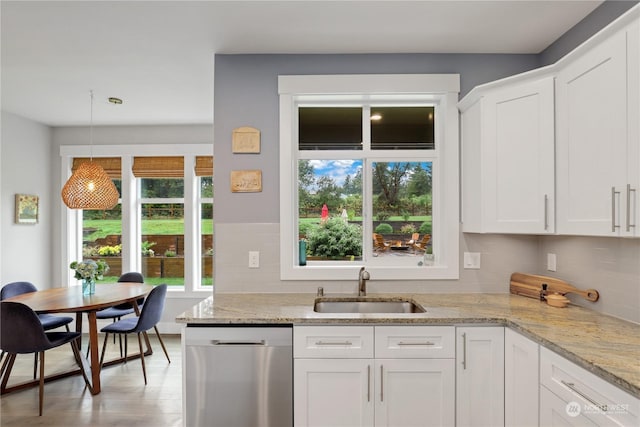 kitchen featuring sink, light stone counters, dishwasher, pendant lighting, and white cabinets