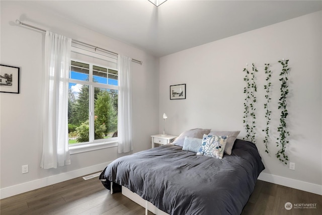 bedroom with dark hardwood / wood-style flooring