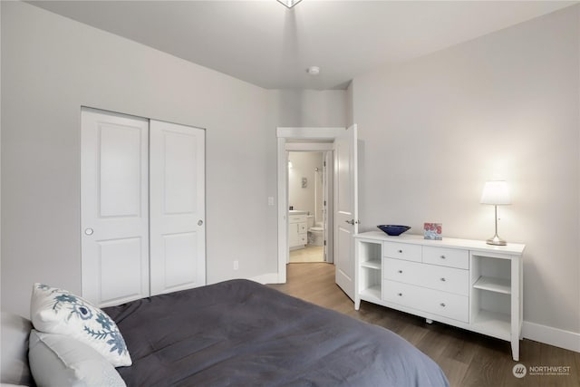 bedroom with dark hardwood / wood-style flooring and a closet