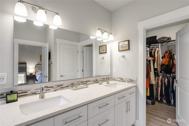 bathroom with vanity, hardwood / wood-style floors, and backsplash