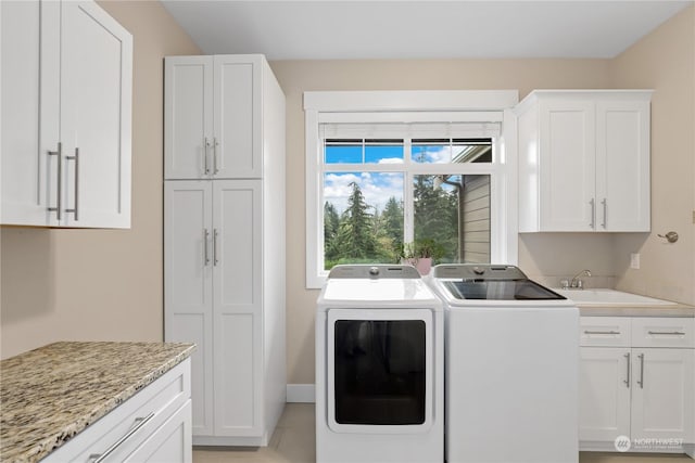 washroom featuring sink, cabinets, and washing machine and clothes dryer